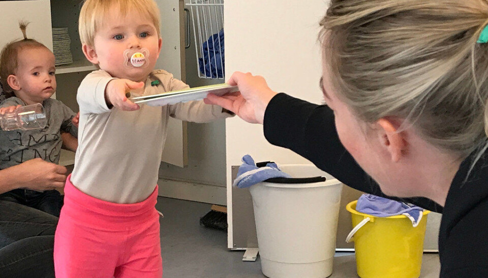 Barna i Rørsangervej barnehage hjelper til med å dekke bordet i overgangen fra lek til måltidet. Barnehagen flyttet tallerkener og bestikk i barnehøyde, slik at Thea og Anine lett kan hjelpe pedagogisk medhjelper Anne Smith (t.h.) med å dekke bordet. Foto: Miriam Lykke Schultz