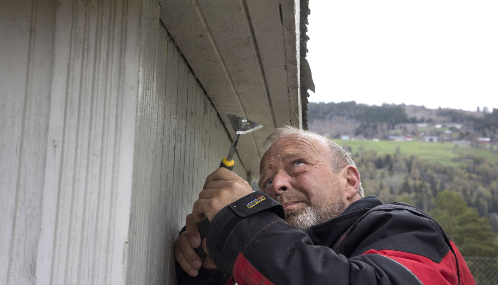 Student Knut Gunnar Melby er tømrer og jobber til daglig på Glåmdalsmuseet i Elverum. Her skraper han for å finne ut hva som var den opprinnelige fargen på den gamle bensinbua. Student Knut Gunnar Melby er tømrer og jobber til daglig på Glåmdalsmuseet i Elverum. Her skraper han for å finne ut hva som var den opprinnelige fargen på den gamle bensinbua.