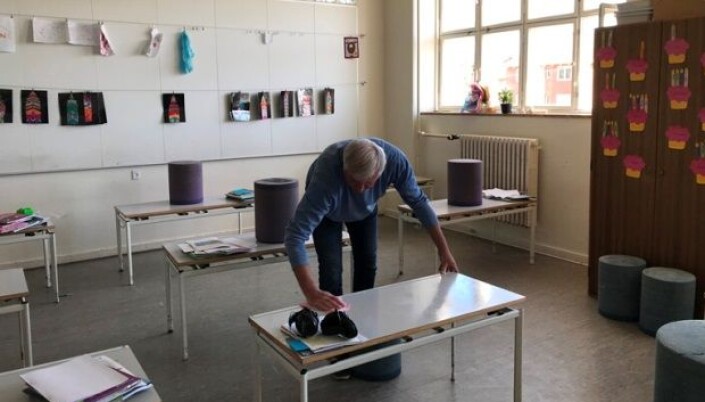 En lærer vasker av en pult. En lærer vasker av en pult.