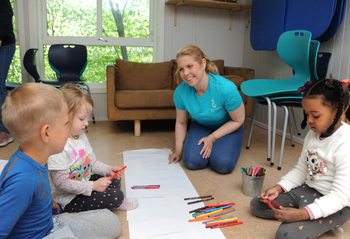 TEGNER PÅ GULVET: Jens Ekaas Arntzen (4), Rebecca Crilly Iddon (4) og Naemi Weldetnsae Habtom (5) koser seg med å tegne på store ark sammen med kunstner Mette Dybwad Torstensen.