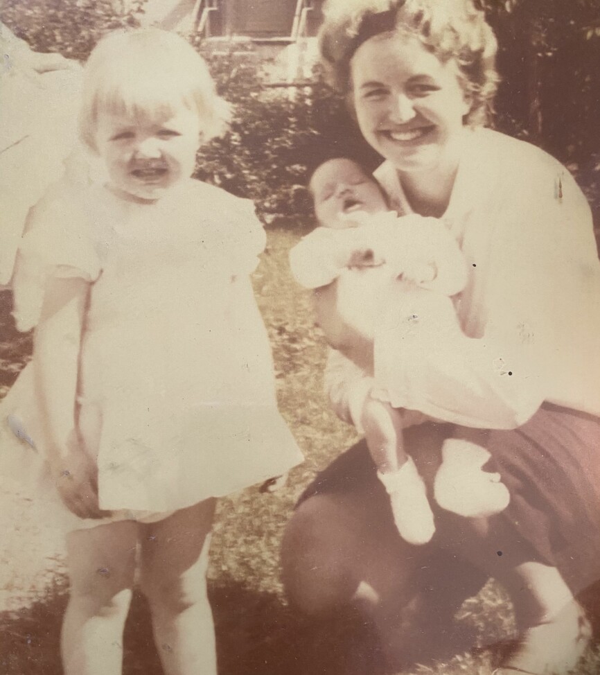 To år gamle Unni i lang, hvit kjole sammen med moren sin, Eva Marie, som leste mye for henne og lillesøsteren Anne Kristine.