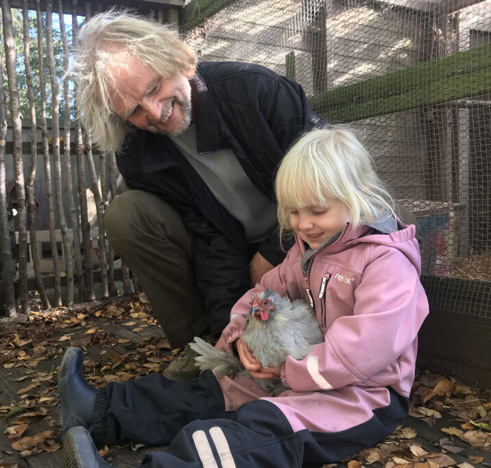 Arnfinn Blichfeldt Ærø og Maria (5) gir høna Lina en liten kosestund i det fri.