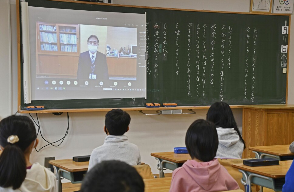 Elever ved en skole i Tokoy får med seg morgenmeldingen fra rektoren ved skolen ved skolestart torsdag 7. januar. Den japanske hovedstaden stenges ned, men skolene holdes åpne.