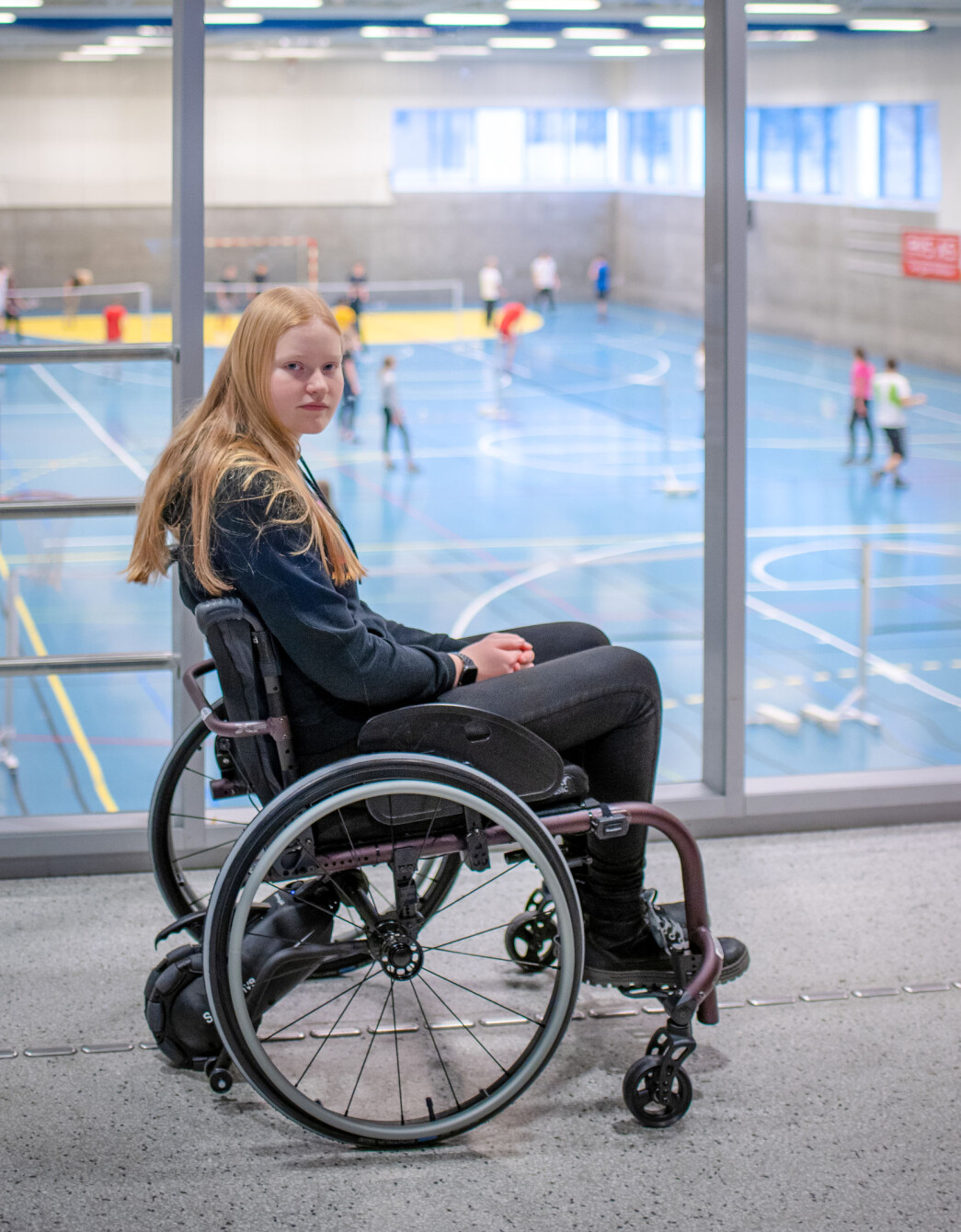 Fra kantina på Hokksund ungdomsskole ser Nelly en annen klasse ha kroppsøving. Når det er hennes klasse som er der nede, er hun aldri tilskuer. Fra kantina på Hokksund ungdomsskole ser Nelly en annen klasse ha kroppsøving. Når det er hennes klasse som er der nede, er hun aldri tilskuer.
