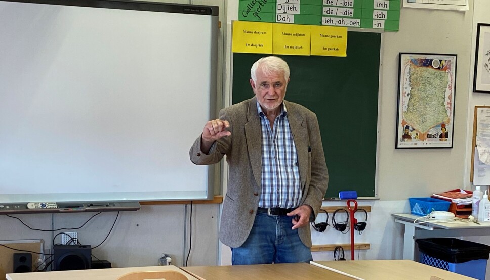 Rolf Aagård viser med fingrene hvordan endingene på samisk skal sies.