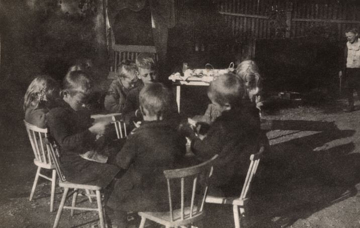 Barna i Rodeløkken Barneasyl i Oslo jobber på gårdsplassen utenfor barneasylet i 1920. Barna i barneasylene spant, vevde og strikket og bidro på denne måten til økonomien i asylene.
