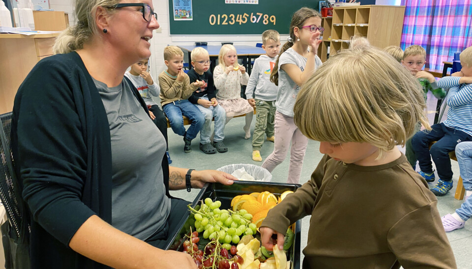 Utdeling av frukt står på timeplanen kvar dag saman med fri leik. Henry i klasse 1 a får velja av fruktfatet som Ingunn Grinde held fram.