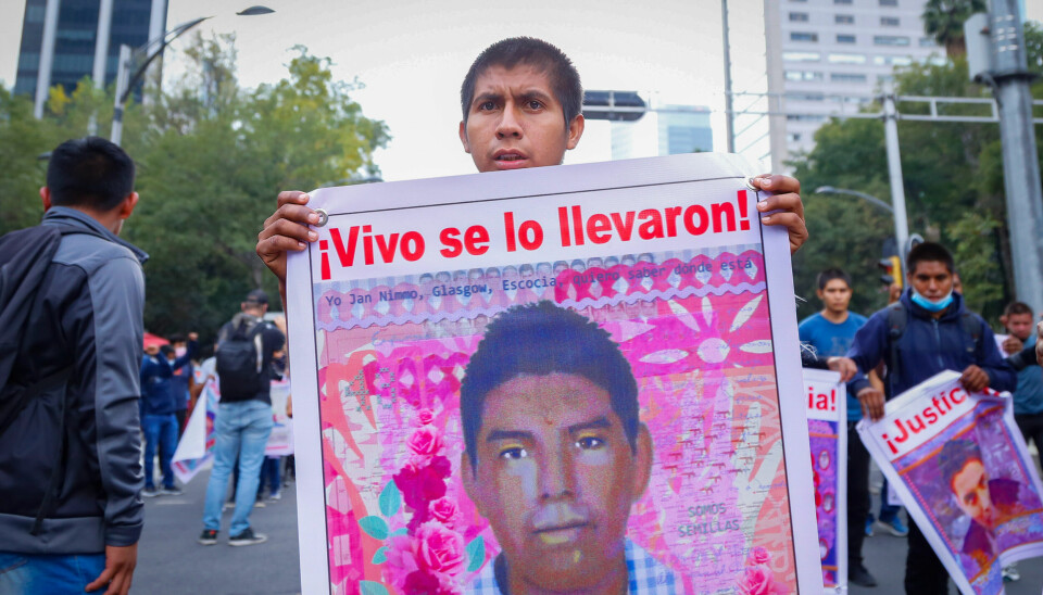 En demonstrant holder opp et bilde av en av lærerstudentene som forsvant for sju år siden.