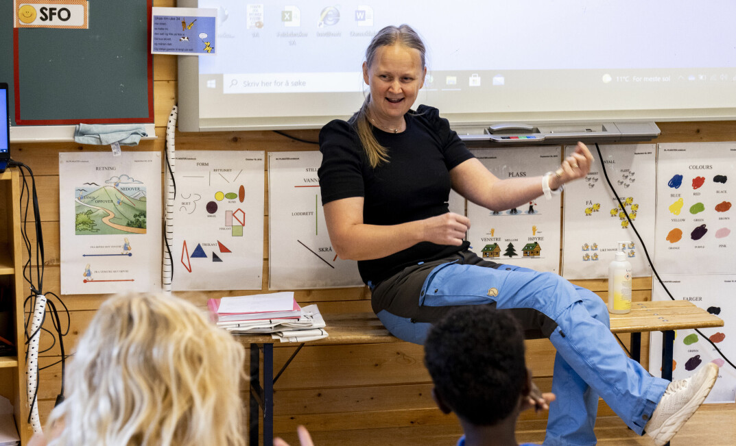 Lærerspesialist Jane Helen Prøven Gregersen spiller luftgitar og får med seg alle elevene til å gjøre det samme.