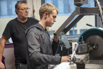 Lærer Stein Dahl følger med når Mathias Kval Hagemoen får prøve seg ved dreiebenken under besøket på Lillehammer videregående skole. Lærer Stein Dahl følger med når Mathias Kval Hagemoen får prøve seg ved dreiebenken under besøket på Lillehammer videregående skole.