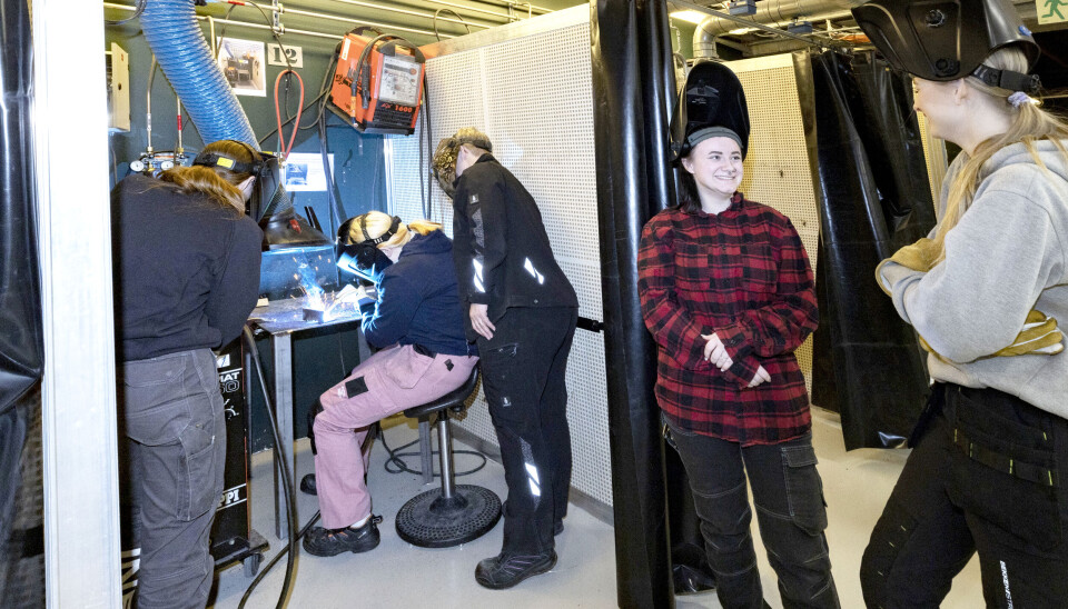 I verkstedhallen på «Katta» står sveiseavlukkene på rekke og rad. På bildet er det Karoline Brenden (17) som prøver seg, mens Eivor Stensrud Aas veileder. Nikita Simona Kristiansen (16) og Leah Sophie Østgård (16) venter på sidelinjen.
