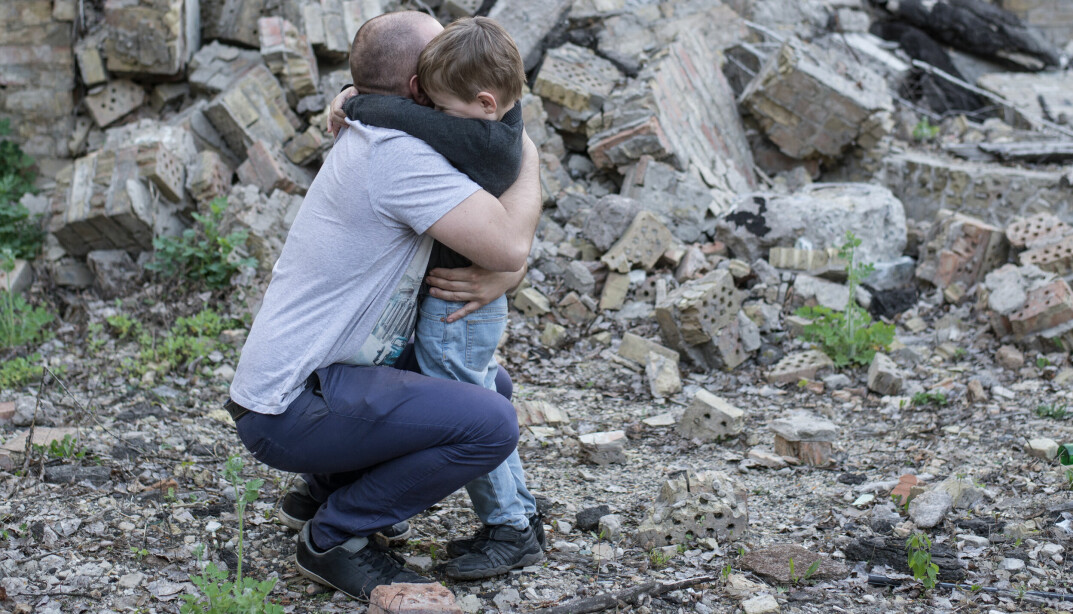 father and son among the ruins of a destroyed building