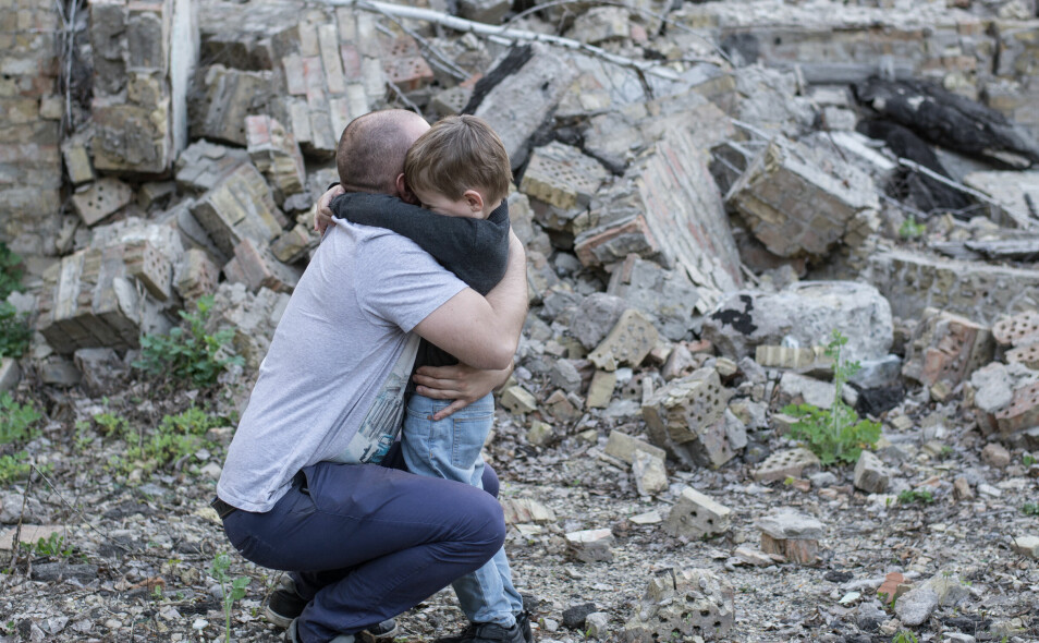 father and son among the ruins of a destroyed building