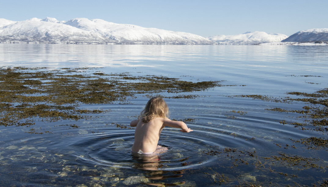 Olivia (4) setter seg rett ned i det iskalde vannet.