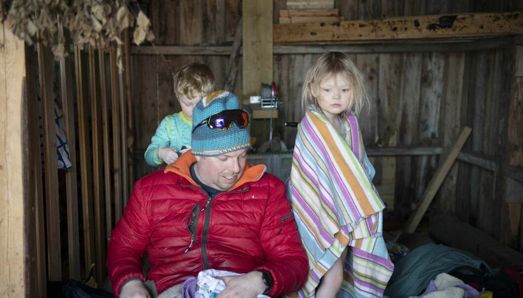 Fagarbeider Tom-Anders Boholm hjelper Ludvig Johan (4) og Nikoline (4) med å få varmen tilbake i kroppen i naustet.