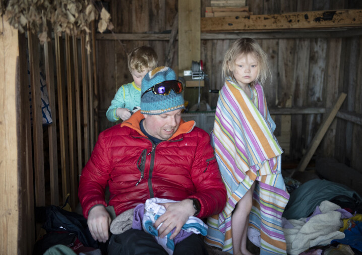 Fagarbeider Tom-Anders Boholm hjelper Ludvig Johan (4) og Nikoline (4) med å få varmen tilbake i kroppen i naustet.