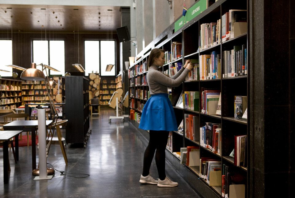 Oslo 2016Ung kvinne låner bøker på Deichmanske bibliotek. Blått skjørt. Leter etter bøker i bokhyllen.NB! MODELLKLARERTFoto: Thomas Brun / NTB