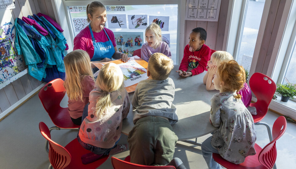 Barnehagens kokk Cathrine Antonsen og ungene rundt bordet tester smakssansene.