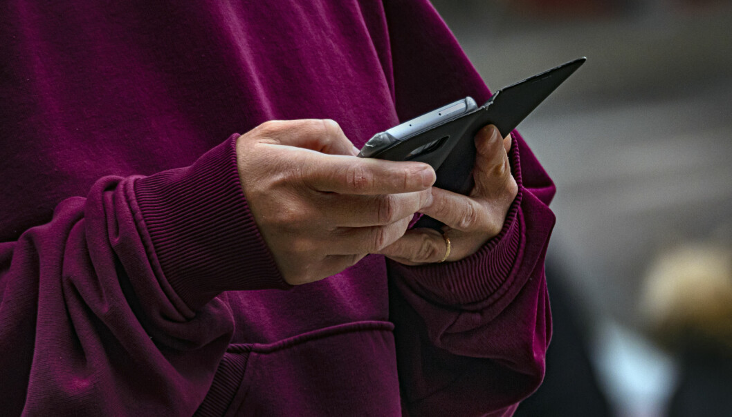 Voksen person med giftering i Vinrød genser sjekker mobil. Foto: © Tarjei E Krogh / Samfoto