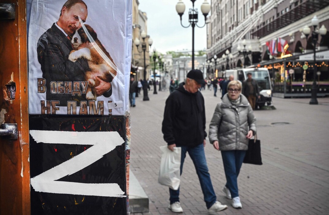 Folk går forbi en gavebutikk i Moskva den 17. mai i år, der det selges t-skjorter med bokstaven Z og et bilde av den russiske presidenten Vladimir Putin. Bokstaven Z er blitt et symbol på støtte til Russlands krigføring i Ukraina, og brukes av russiske myndigheter og av presidentens støttespillere.