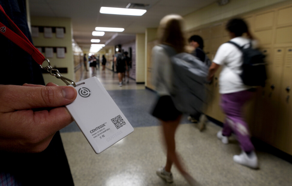Brent Kiger, sikkerhetssjef i skoledistriktet Olathe i Kansas, viser fram panikkalarm-knappen mens elever haster forbi i gangen bak ham. Slike knapper blir stadig mer utbredt på amerikanske skoler i forsøket på å beskytte barna mot skoleskyttere.