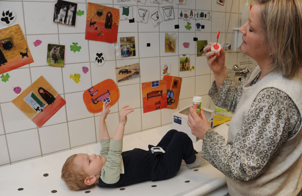 Støttepedagog Synne Jorde Brekke og de andre barnehageansatte baker inn mye trening i leken med Elias, som å la han strekke seg etter såpeboblene.