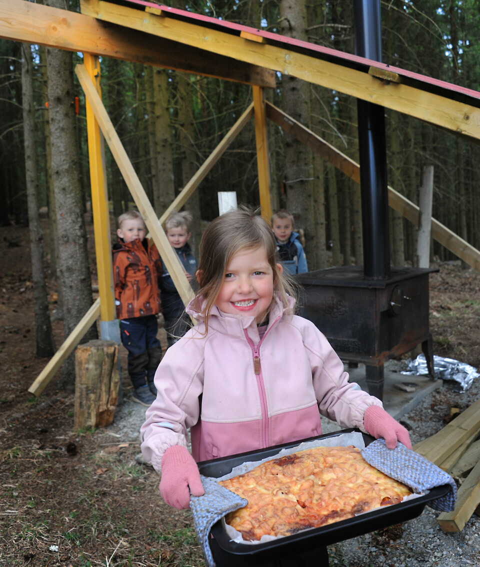 I Røysum barnehage på Hadeland har de fortsatt å lage mat ute også etter pandemien. Natalie Dynna (5) bærer på en nystekt pizza til Magnus Helmen Heggen (5) Jacob Egge Sørlie (5) og Jonas Johansen (5).