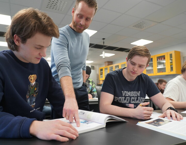 Kjemilærer Ola Bjelland bidrar til løsning av oppgaver sammen med Sander Joa til venstre og Martin Fisketjønn til høyre.