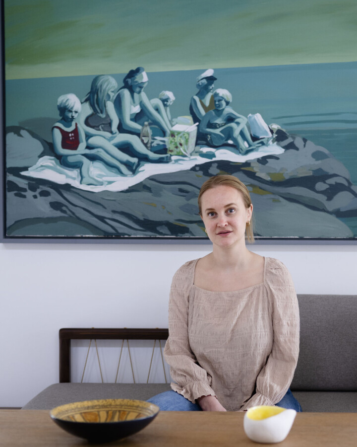 Standup-komiker og lektor Sofie Frøysaa har skrevet boka Alt bra sammen med mora Ellen Frøysaa. Den tar for seg Sofies oppvekst med ufrivillig skolefravær på grunn av hudproblemer og mobbing, og OCD og tourettes-diagnose. Bildet bak henne har moren malt. Den lille jenta i rød badedrakt er mammaen.