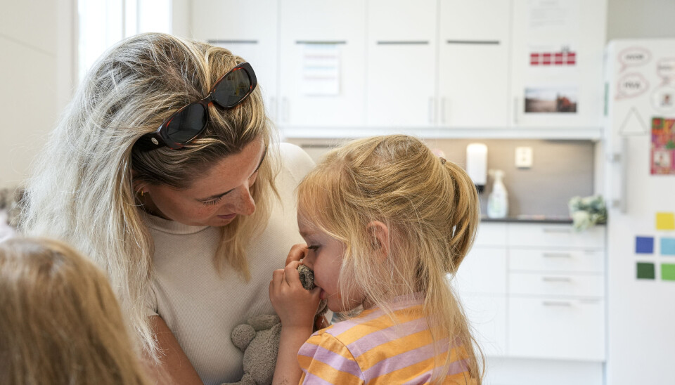 Pedagogisk leder Frida Løw tar ett av barna opp på fanget under spisepausen på avdelingen.