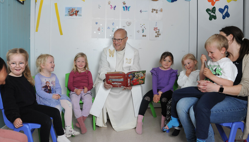 Prest Øystein Vaaje leser fortellinger om Jesus til barna i Eikely barnehage: Van Nun Sung Thawng (5) (f.v.), Ronja Johansen (4) Tiril Grude (4), Maja Grimstad Simonsen (4), Eva Gumeri (4), Elena Louise Olsen (4) og Sander Jørgensen Rydningen (5) på fanget til pedagogisk leder Ragnhild Hurv.