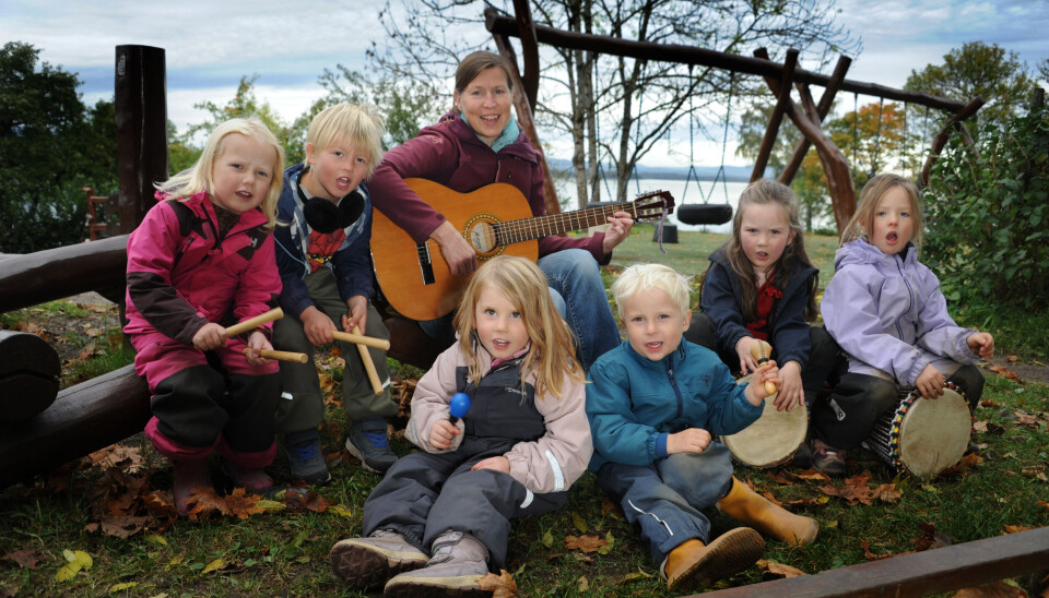 Pedagogisk leder Kathrine Helgesen tar ofte med musikken ut i barnehagen og spiller gitar mens Emilie (bak t.v.), Mikkel, Zoe (foran t.v.), Johan, Emily og Elsa stemmer i med rytmepinner, rytmeegg og djember.