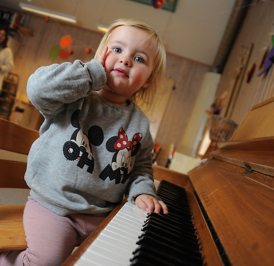 Solveig utforsker pianoet, som er et av mange instrumenter som står lett tilgjengelig i barnehagen slik at barna kan spille på dem.
