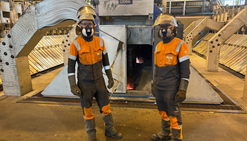 Teamleder Viktor Eikebø (t.v.) og lærling Sindre Langseth foran en av ovnene – elektrolysecellene – hvor de lager aluminium.