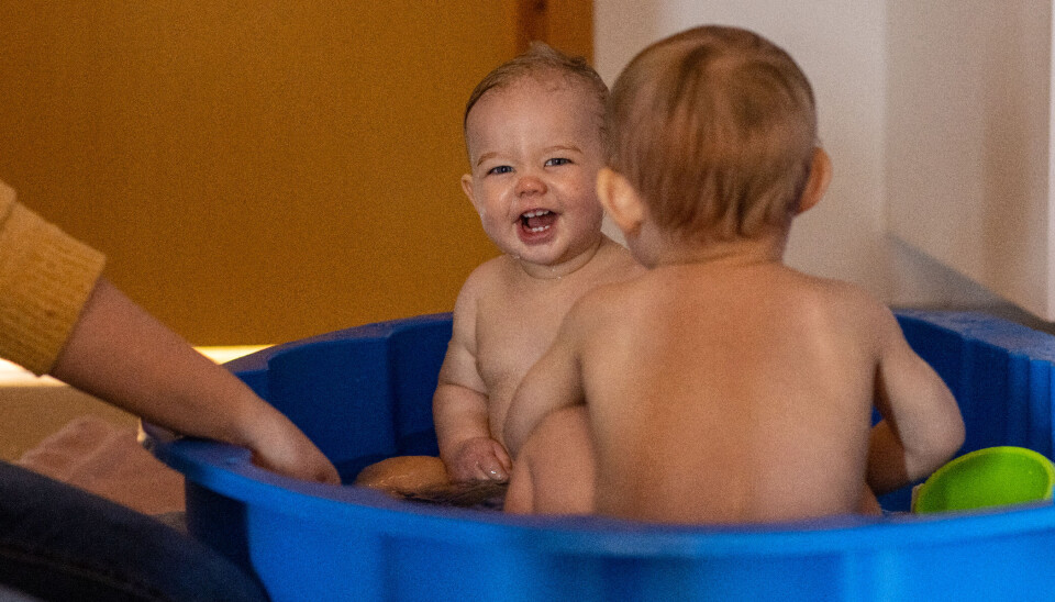 Hermine og Oliver har stor glede av å leke med kopper og vann til lyden av gresshopper.