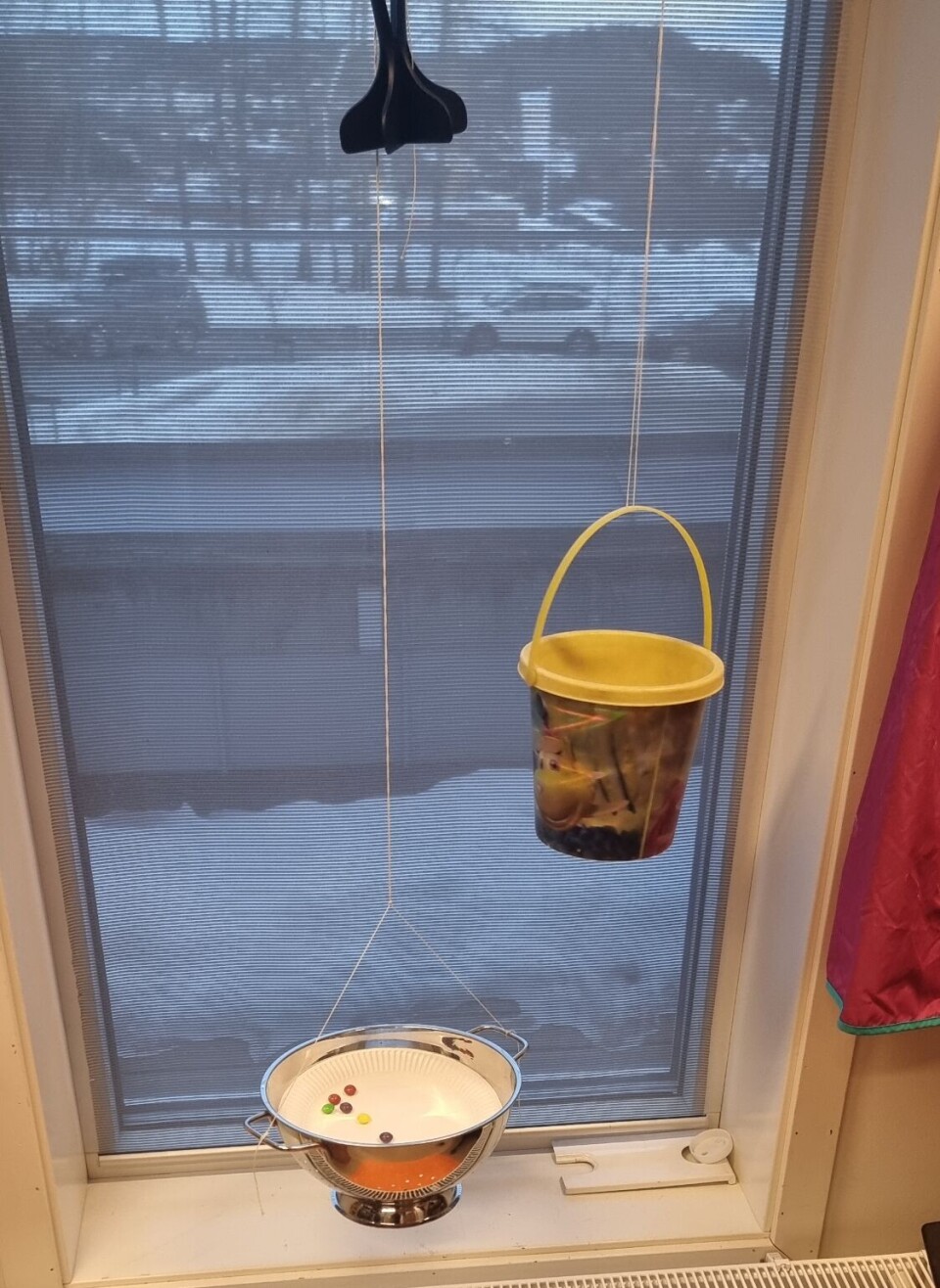 STEG 4: Det ble lagt et stort ark på gulvet under fatet med godteri, med lim på, og vi hang opp en bøtte med fjær. Nå var spøkelsesfellen ferdig.
