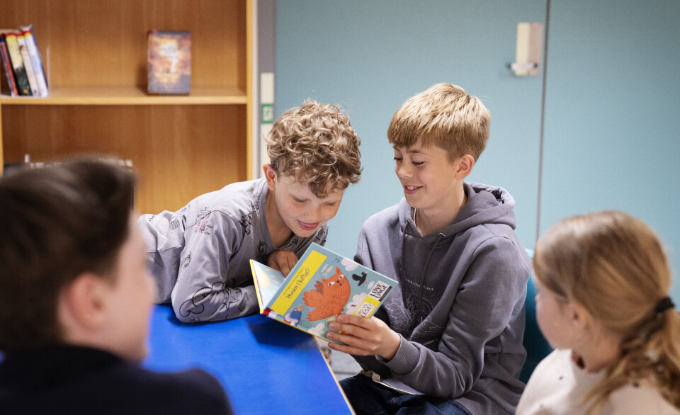 Bjørn i 8 C har funnet fram en bok med morsomme gåter om tullete dyr. Førsteklassingen Caleb vil gjerne lese. Emma og Kaiden er også med.