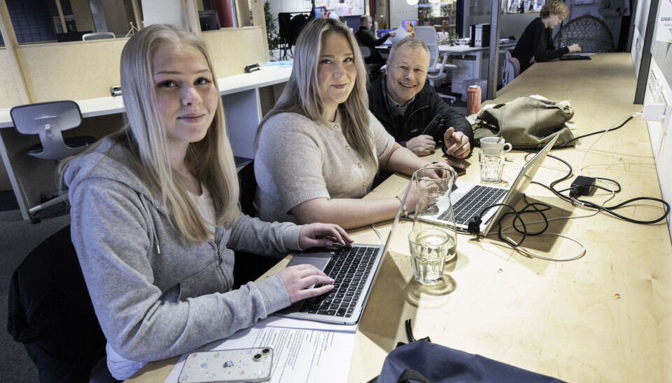Bertine Svendsgard (nærmest) og Joleen Wels i kontorfellesskapet der de er utplassert. Her lager de promoteringsmateriale for et arrangement. Arnstein Lien er innom for å høre hvordan jentene trives.