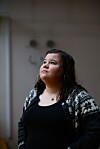 Lærerstudenten Miriam Joy Elder ser oppover i et innendørs rom med mørk bakgrunn.