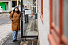 Lærerstudent står i brun vinterkåpe på en gate ved NLA Høgskolen.