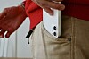 Bildet viser en iPhone som holdes halvveis oppe fra en bukselomme.