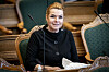 Inger Støjberg sitter i Folketinget med dokumenter foran seg.